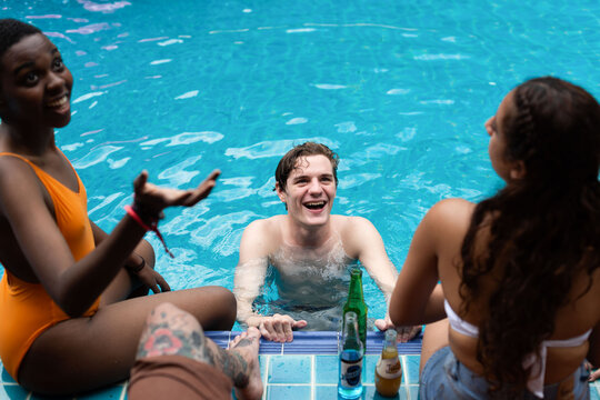 Group of friends enjoying a pool day, laughing and relaxing.