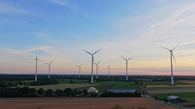 Windmill in a rural area. Offshore wind park. Wind turbines farm. Alternative renewable energy generation. Green energy concept. Organic harvest in farm field. Agricultural harvest
