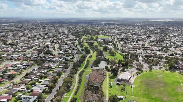 Aerial view of the Lollipop Creek green buffer and wetland stormwater reserve integrated with residential housing and sports fields in Wyndham Vale, Melbourne, Australia.