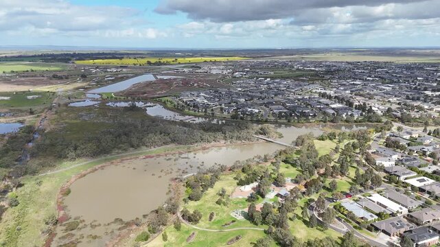 Aerial high-angle view of preserved natural wetlands and open greenfield land bordering newly developed residential estates in Werribee, Melbourne, Australia. Rural-Urban Fringe Interface and housing