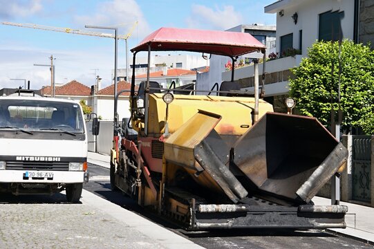 Asphalt paver machine working on road construction in city
