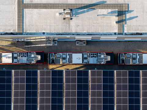 Aerial view of the EBS Public Transportation BV electric bus charging station featuring solar panels on the roof and parked electric buses in Purmerend, North Holland, Netherlands.