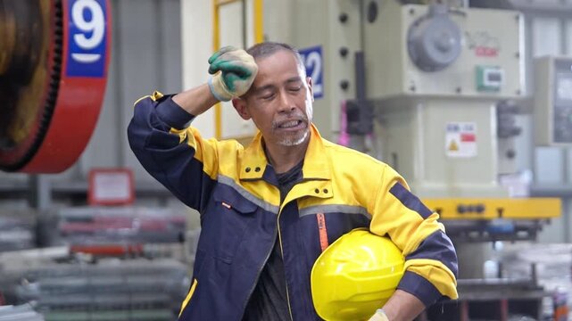 Industrial engineer wearing a yellow hard hat and safety uniform while working in a manufacturing factory, representing engineering, auditing, quality control, and industrial business.