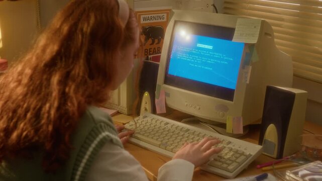 Rear view of redhead teenage girl typing on vintage keyboard, encountering blue screen error on CRT monitor and turning it off in frustration. Ideal for retro tech support or software failure ads