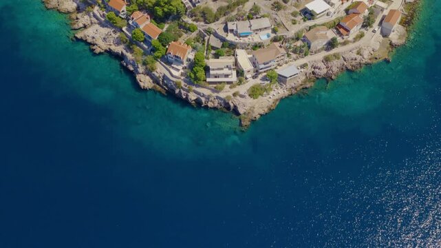 Aerial drone flight over the turquoise Adriatic coastline of Primo&scaron;ten, Croatia, with smooth upward and forward movement revealing rocky shores, coastal homes, clear water and Mediterranean landscape