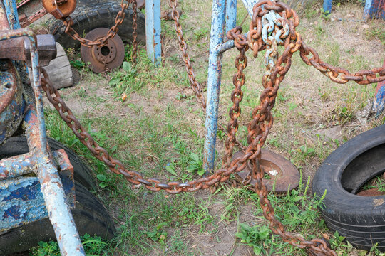 Heavy rusty steel chains hanging on brutal homemade training equipment