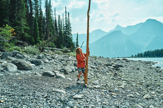 boy holding a very long stick on the beach