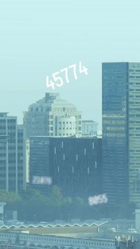 Animation of multiple changing numbers floating against aerial view of cityscape