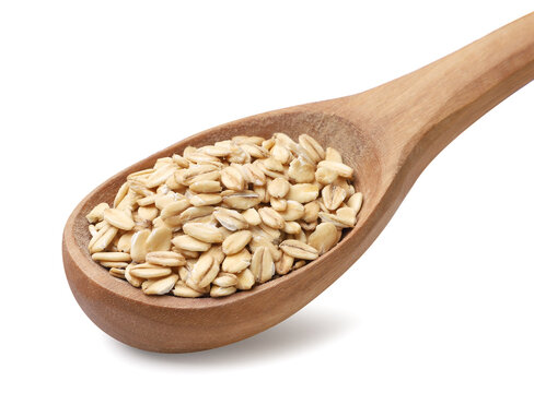 Oat groats in a wooden spoon on a white background. Isolated