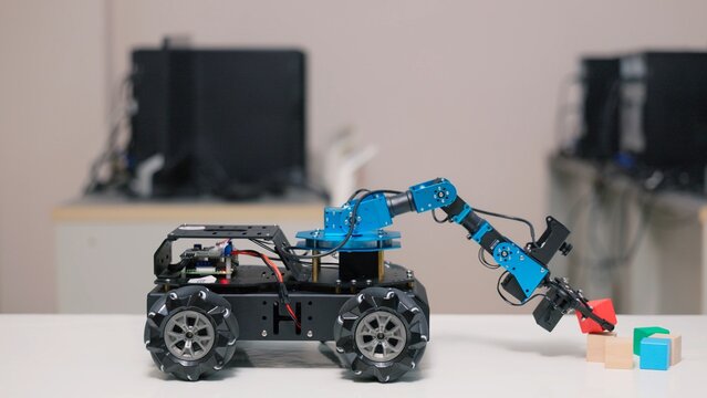Asian kid pupil happy learning robotics programming and controlling robotic arm in science class. Creative STEM education, future technology innovation, school laboratory and child study concept.