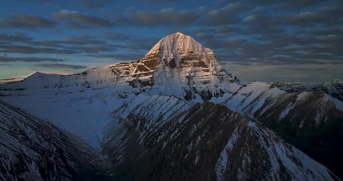 Aerial view of majestic mount kailash peak illuminated by golden sunrise light.