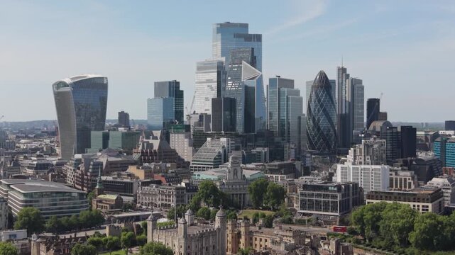 Dynamic aerial drone footage capturing London's iconic financial district skyline and Tower of London.