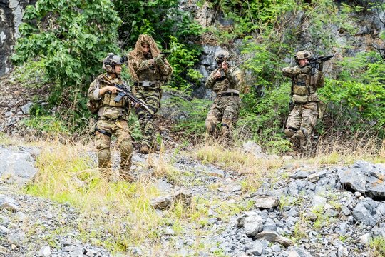 Soldiers training in a rocky area during daylight hours
