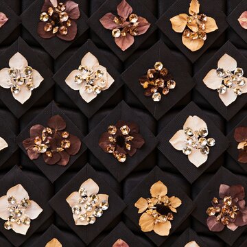 Black mortarboards arranged in a repeating grid, decorated with sparkling rhinestones and pressed flower petals for graduation crafts and packaging design