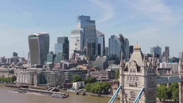 Aerial drone footage showing London cityscape with iconic Tower Bridge over River Thames on sunny day.