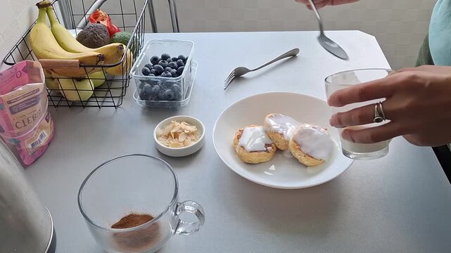 Making a simple breakfast with pancakes and berries in a kitchen with fresh fruits on the table