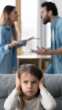 Distressed child covering ears while parents argue in background, conflict stress, childhood anxiety, emotional isolation, domestic tension, upset girl indoors parenting concern