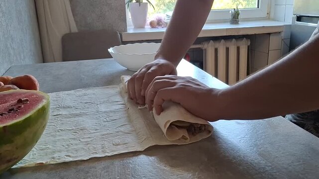 Making a simple wrap with fresh ingredients in a kitchen