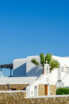 Mykonos island architecture featuring white church and palm tree