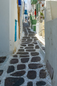 Mykonos narrow street with traditional whitewashed buildings and cobblestone path
