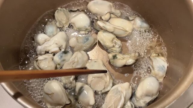 生牡蠣を炒めて水分を飛ばす