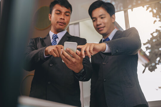 Businessman using smartphone, meeting to discuss the situation on stock market, talking business plan for investment. Selected focus