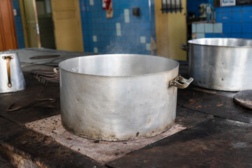 Fototapeta premium Large aluminum stock pot boiling on a stove top in an industrial kitchen
