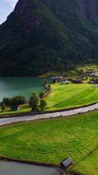 vertical video of Norwegian nature near Odda village, pristine glacier lake and waterfall on Sorfjorden fjord in western Norway, hiking and travel in Scandinavia, Scandinavian holiday. 