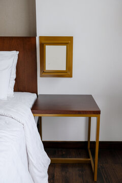 Modern wooden bedside table and nightstand in a hotel room interior