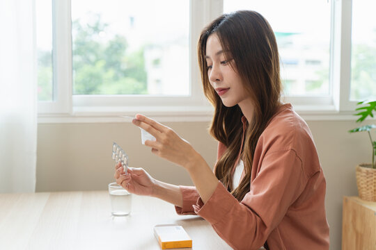 Mindful Health Habits: Engaging in Informed Wellness - A Person Deliberates Supplement Information Before Consumption for Optimal Nutritional Awareness and Personal Well-being.