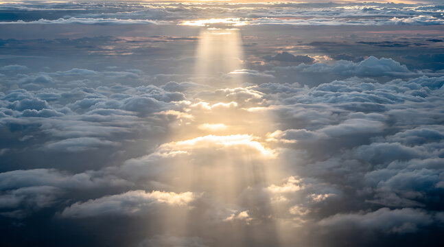 Serene aerial view capturing sun rays piercing through a layered cloudscape during a tranquil sunset sky