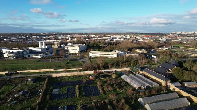Aerial of industrial campus, silos and allotments on the city fringe