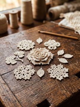 Collection of handmade crochet lace flowers and leaves on wooden workbench