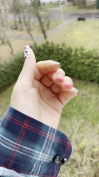 Creative home gel manicure with pink French tips and leopard spots, woman showing freshly painted nails against an overcast day, trendy nail art, beauty lifestyle, playful feminine hand closeup
