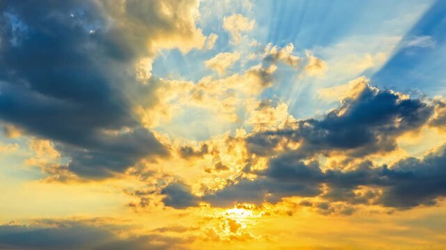 Majestic golden sunset sky with dramatic clouds and glowing sunbeams