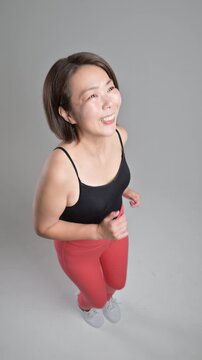[スローモーション]笑顔で元気にフィットネス運動を楽しむ40代の女性、更年期に健康とダイエットを意識したランニングや走る歩くトレーニング俯瞰の縦動画