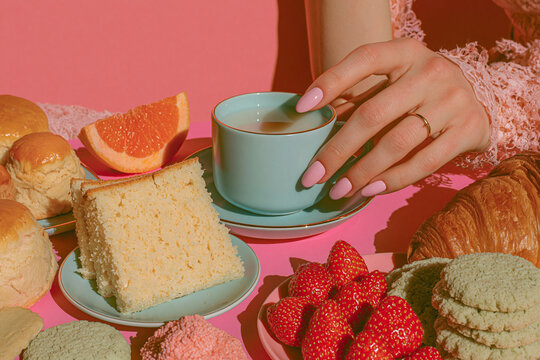 Slice of layered cake on a plate with fresh strawberries and a hot cup of tea