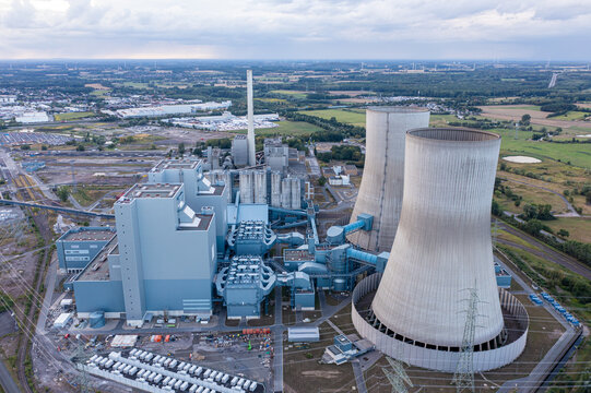 Aerial view of the RWE Westfalen power plant with its large cooling towers, industrial buildings, and surrounding green landscape in Hamm, Nordrhein-Westfalen, Germany.