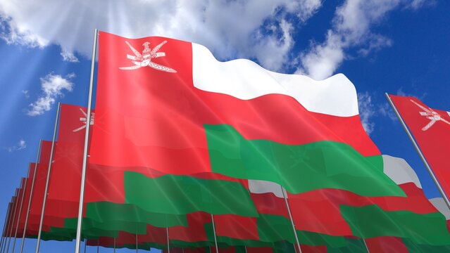 Multiple Oman flags waving on blue sky