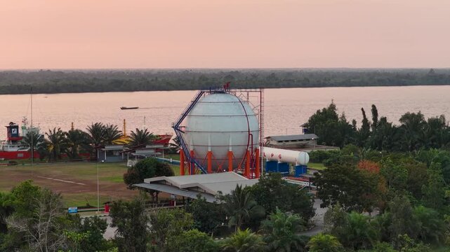 Spherical gas container situated by the river in South Kalimantan at sunset