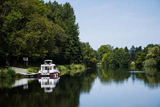 Bateau de croisi&egrave;re sur un canal. Vacances sur une voie navigable. Se d&eacute;placer en bateau. Petit bateau sur l'eau.