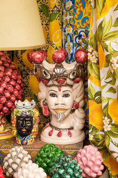 Sicilian ceramic Moor's head displayed among fruit and fabric