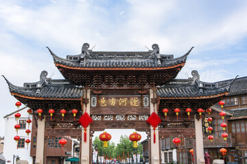 Fototapeta premium Traditional Chinese Gateway Decorated with Red Lanterns in Historic Old Town