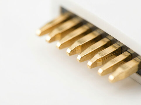Gold plated connector pins close up, electronic component with shiny metallic contacts, technology detail macro image
