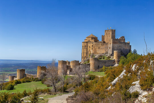 Castle of Loarre in Aragon, Spain, side view. Romanesque fortress with medieval defensive walls and towers on mountain slope