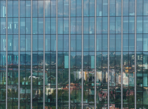 Aerial view of the glass facade of the Olivia Business Centre reflecting the surrounding urban landscape in Gdansk, Pomeranian Voivodeship, Poland.