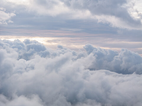 Aerial view of dense white clouds filling the sky with soft light filtering through the atmosphere over France.