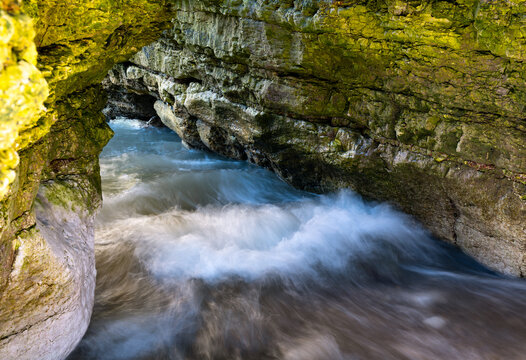 Waves surging through a sea cave at North Landing, Flamborough Head on the rugged Yorkshire coast, England.