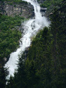 Waterfall in Norway rocky mountains and coniferous forest moody scenery, beautiful travel destinations in Scandinavia natural landmark in Hardanger