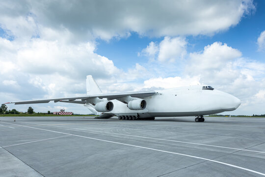 Loading white big heavy cargo airplane. The rear cargo compartment is open